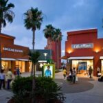 Exterior view of Rio Grande Valley Premium Outlets with blue sky and palm trees