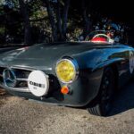 Front view of the barn find 190 SL Mercedes, covered in dust under a custom car cover.