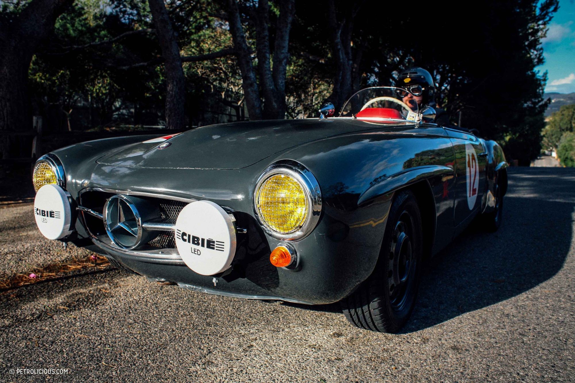 Front view of the barn find 190 SL Mercedes, covered in dust under a custom car cover.